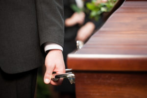 carrying casket at funeral to cemetery after filing a lawsuit for wrongful death with attorney